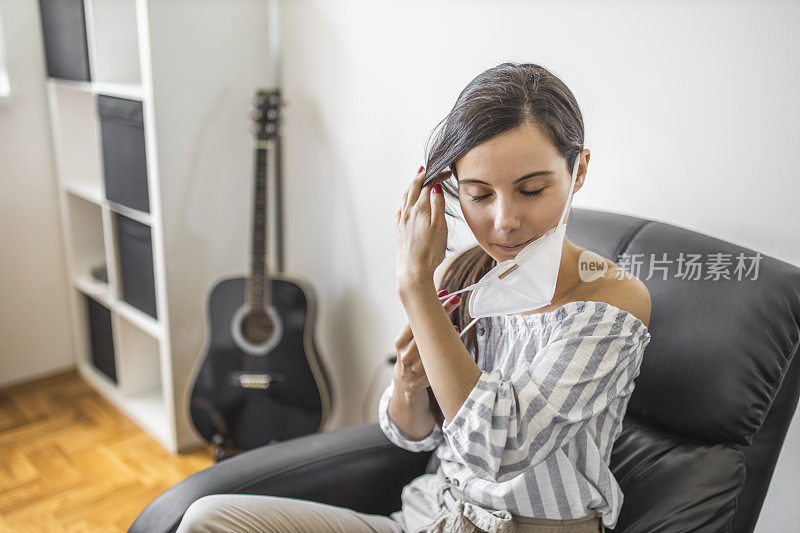 年轻妇女戴着防护口罩进行冠状病毒隔离的肖像