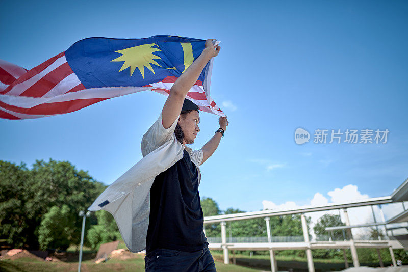 马来西亚滑板手举着马来西亚国旗庆祝独立日