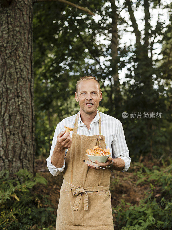 男男厨师在户外用鸡油菌和煎锅