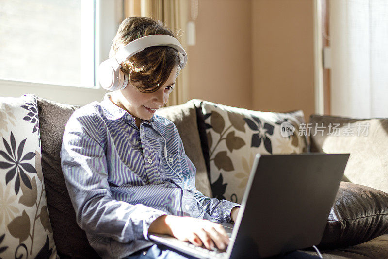 快乐的孩子使用笔记本电脑和耳机