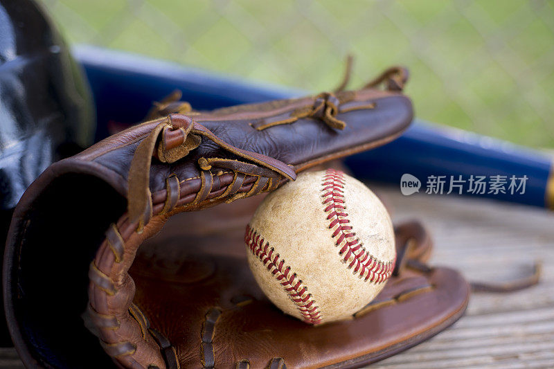 棒球赛季到了。教练席上的球棒、手套、头盔和球。