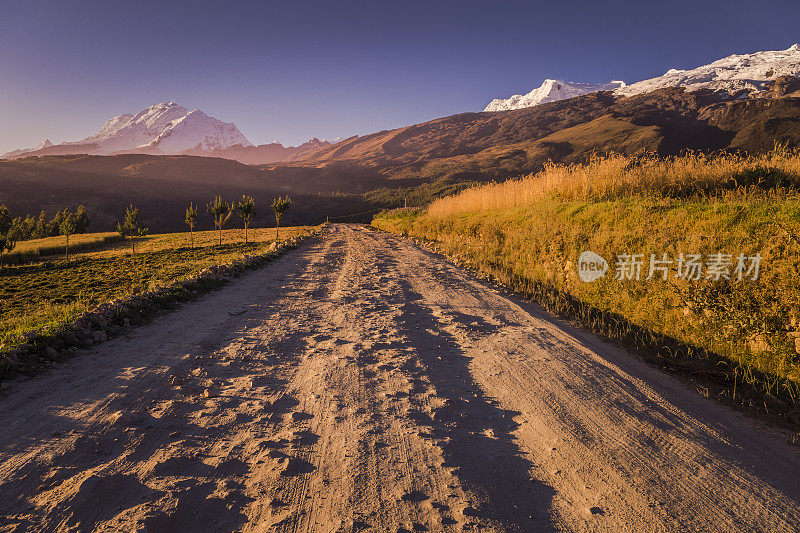 秘鲁，瓦拉兹附近的安第斯山脉，夕阳下通往布兰卡山谷和华斯卡兰山脉的乡村公路