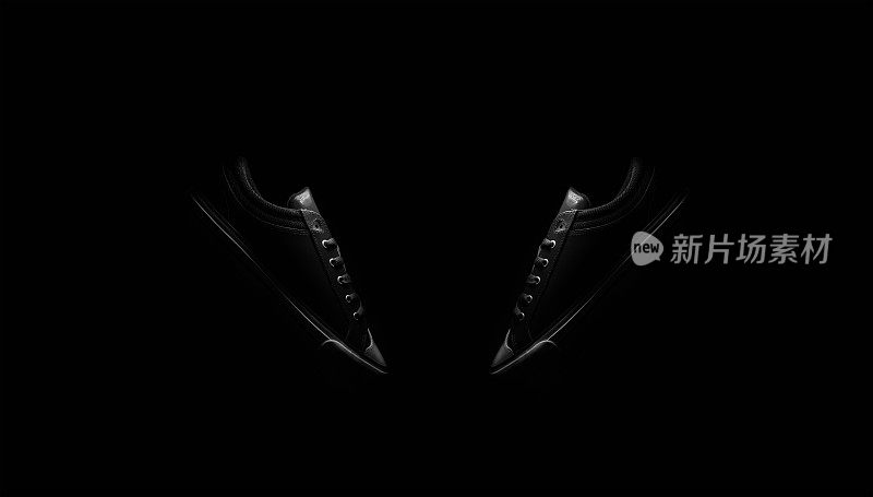 黑色和白色照片的复古低顶运动鞋鞋孤立在黑色背景。