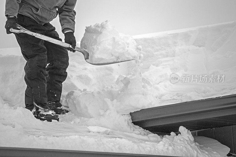 老人从屋顶上铲雪