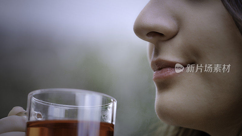 头部拍摄极端特写的西班牙裔年轻女子喝一杯芙蓉热茶在户外露台