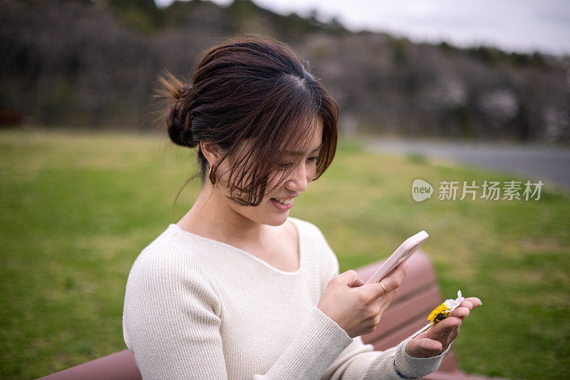 年轻女子正在拍手上的花