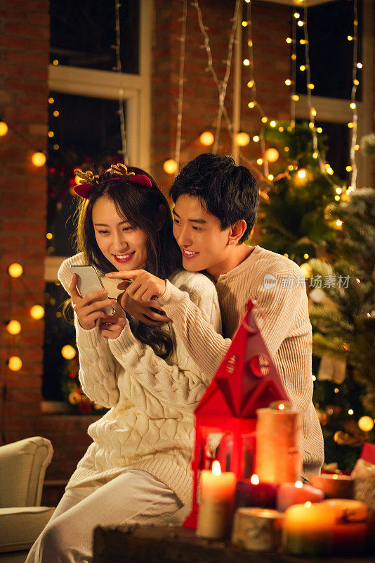 幸福的年轻伴侣在家玩手机