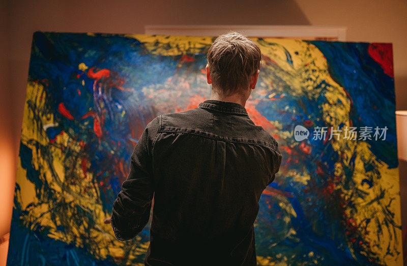 一位男性艺术家正在欣赏他的艺术作品