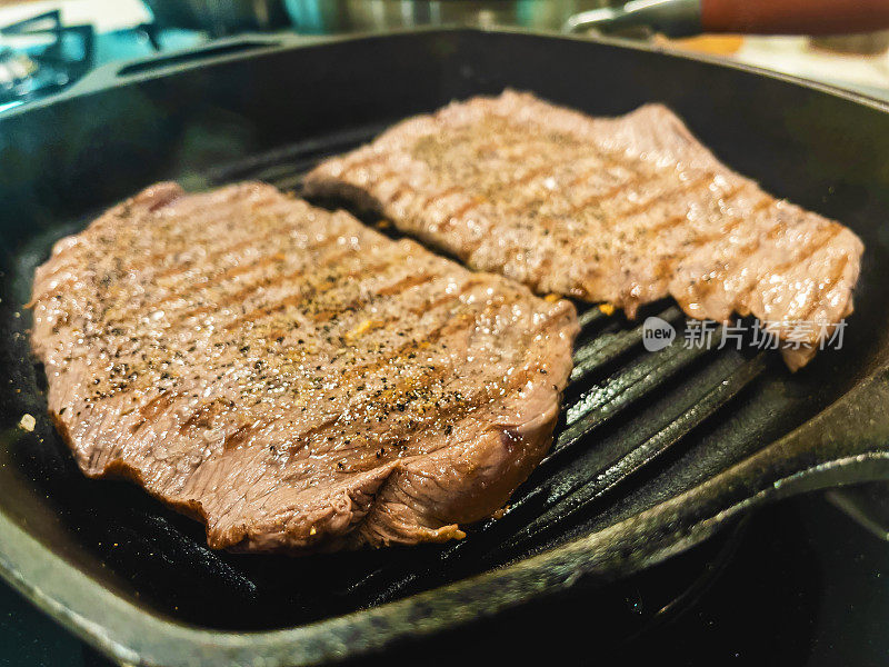 牛肉西冷牛排肉在一个开放的炉灶煤气火焰上煮