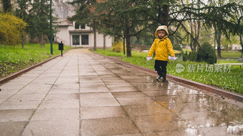 孩子们在水坑里玩纸船