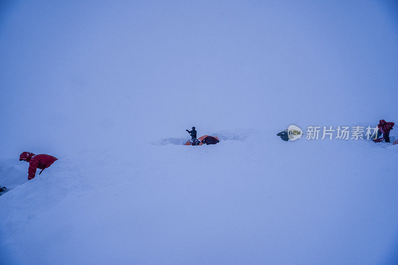 朋友们试图从新鲜的深雪中挖出帐篷