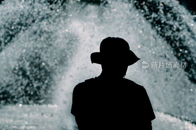 一个男人站在喷泉前的剪影