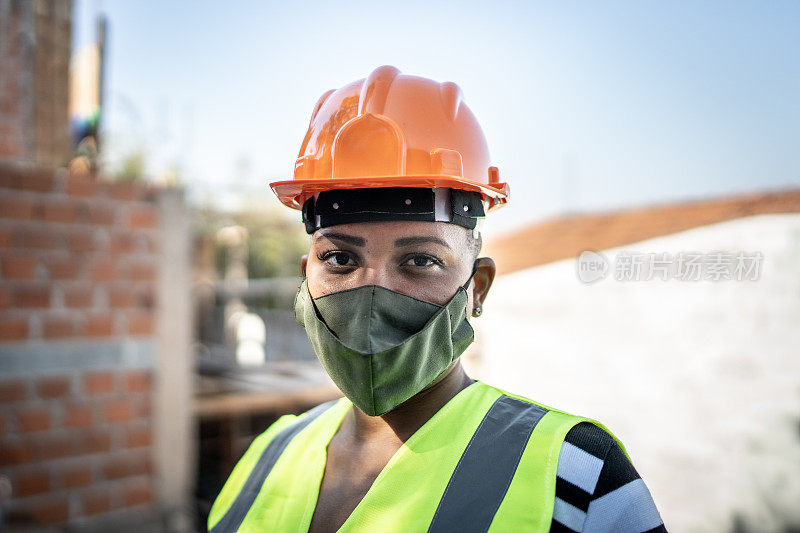 一名女建筑工人在工地上戴防护口罩