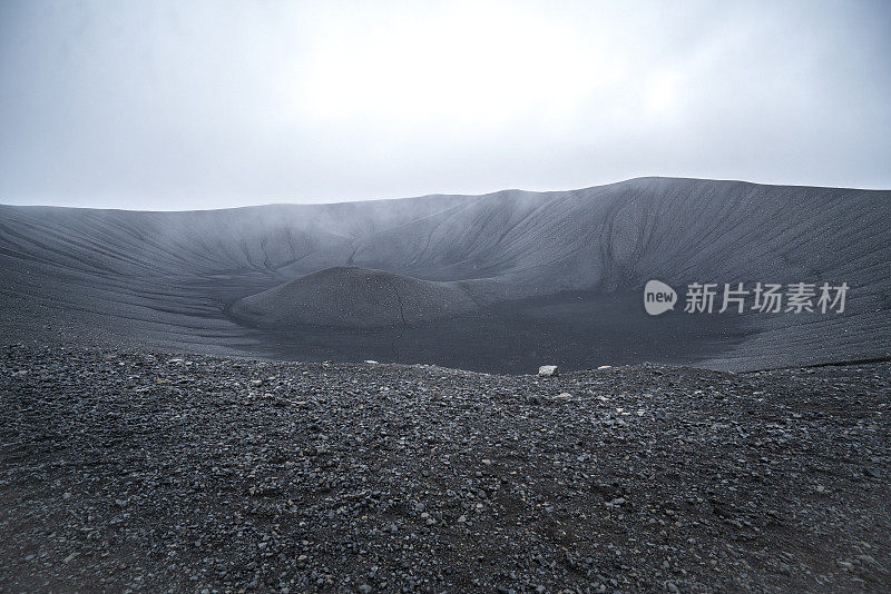 在冰岛北部的赫弗尔火山口上徒步旅行的游客。