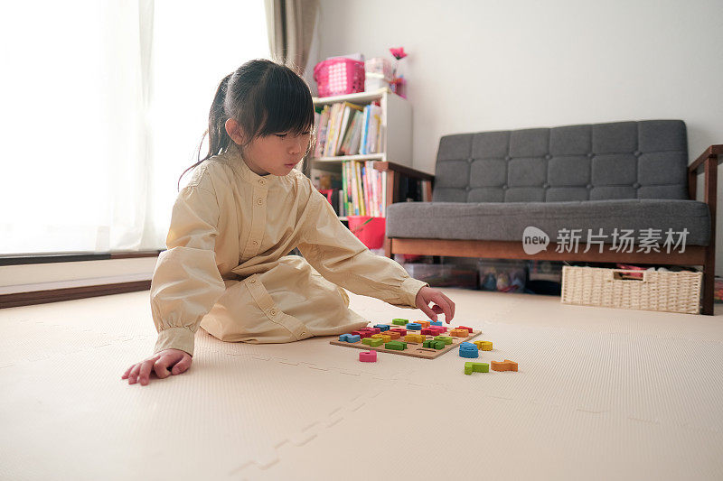 女孩用玩具积木学习字母