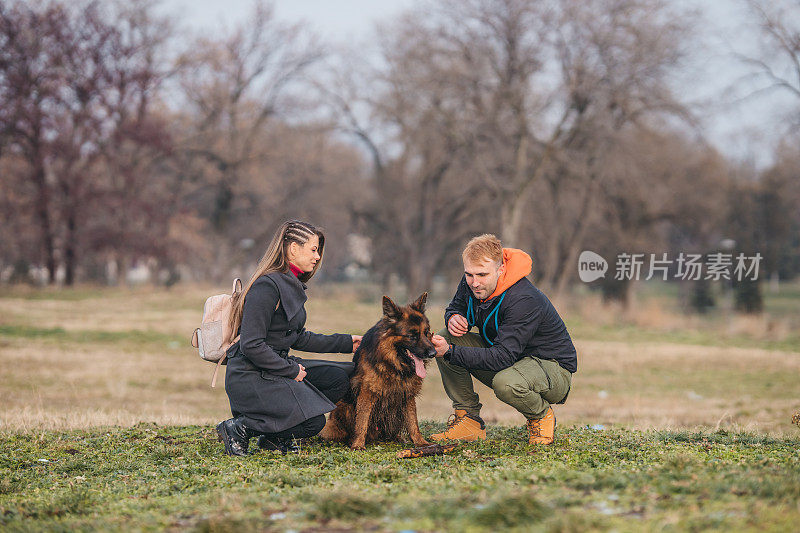 一对恩爱的夫妇和一只德国牧羊犬在公园里