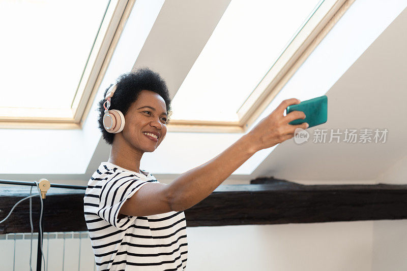 一个快乐的非洲女人在家里自拍的肖像