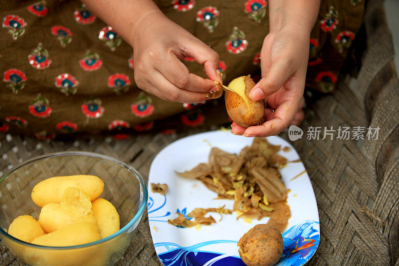 女人在家里削土豆