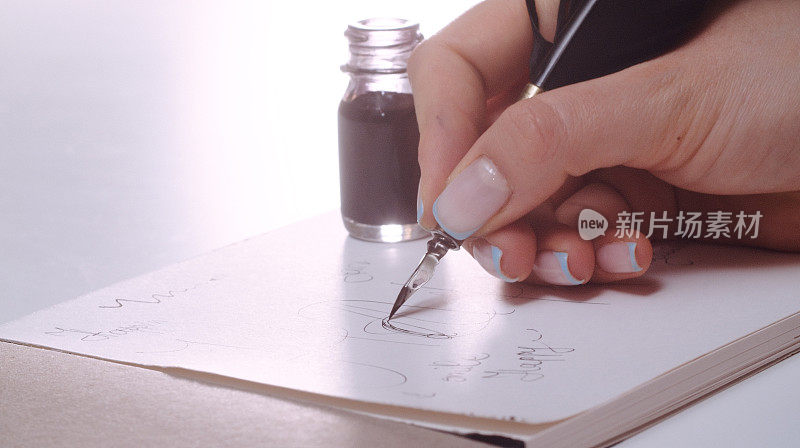 女人用羽毛笔和墨水瓶书写的笔迹，拉近。