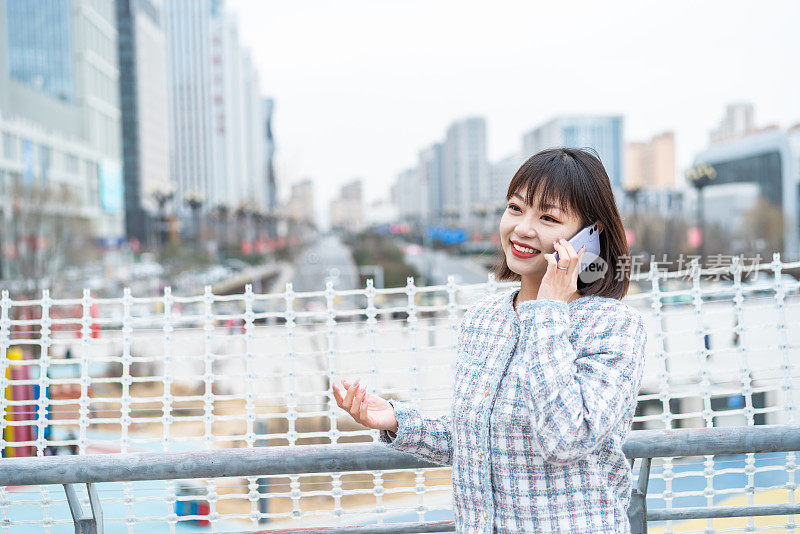 亚洲年轻女子在城市街道上使用智能手机