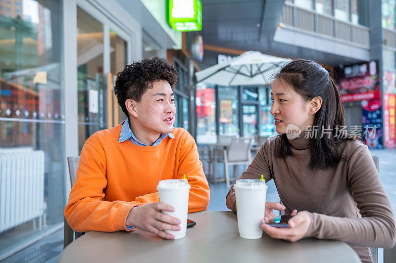 年轻的亚洲异性恋情侣在咖啡店约会