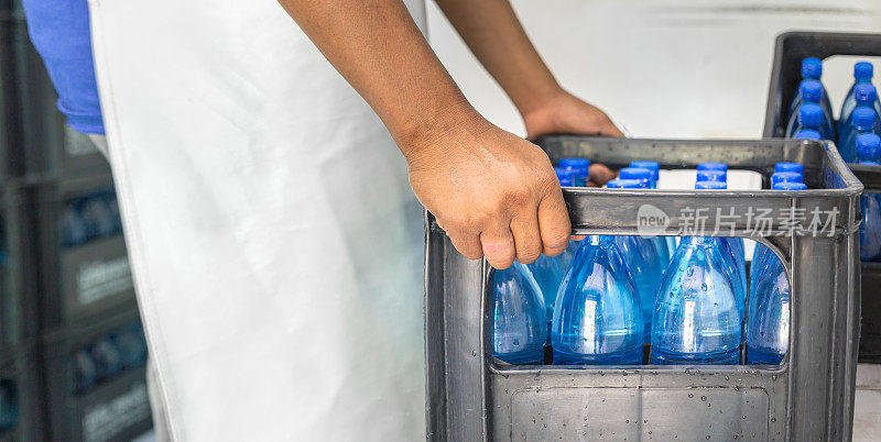 图为，清洁饮用水生产企业清洁饮用水工厂生产饮用水的工人正在将蓝色水瓶包装成饮用水产品