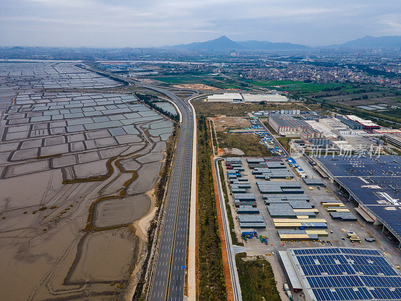 沿海工业厂房和道路屋顶新能源太阳能光伏发电鸟瞰图