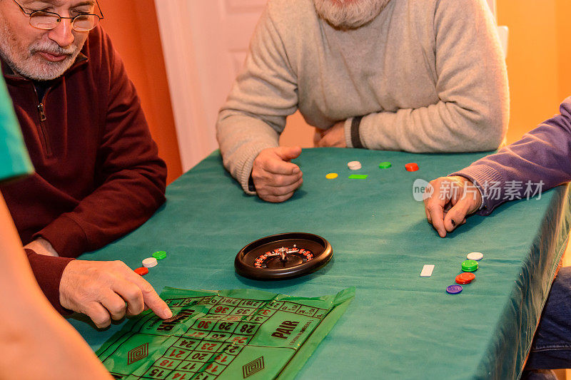 老年人在社交聚会上玩轮盘赌游戏，玩得很开心。