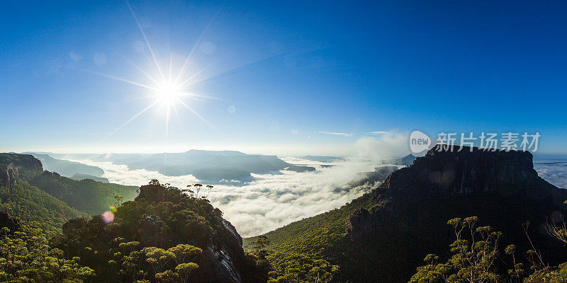 在日出时，云和滚动的雾填满山谷的山顶视图