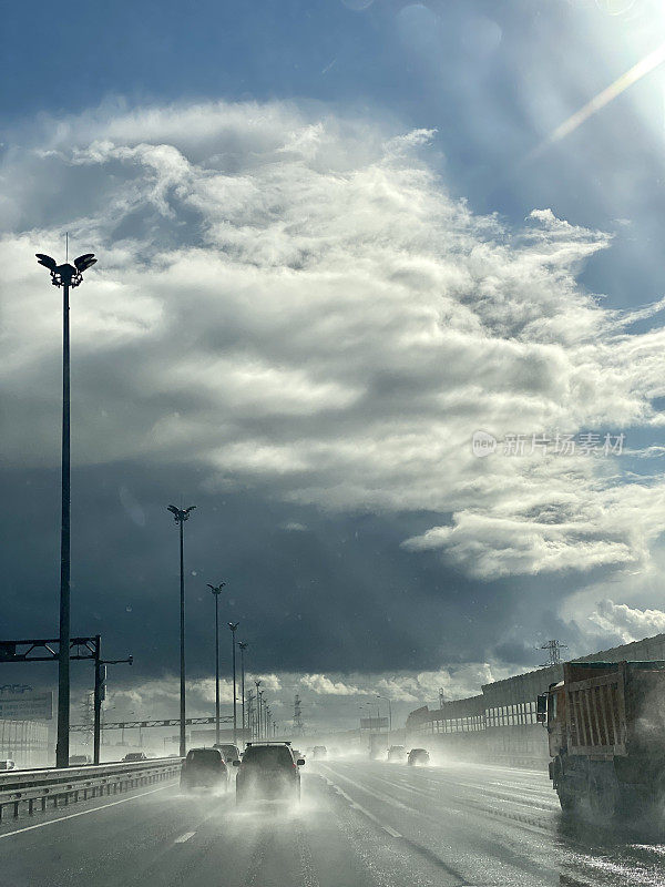 公路上的交通在阳光下和雨，俄罗斯