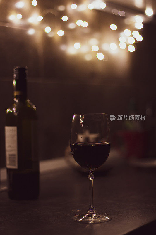 桌上有一杯红酒和一瓶红酒。傍晚静物。酒吧里有红酒。酒精饮料概念。餐厅里的酒杯和红酒。