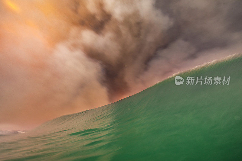 天空中的火，因为浓密的黑烟云形成的丛林火灾反映在海洋表面