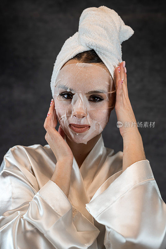 女性用白色毛巾敷布片美容面膜，清洁护理面部隔离的黑色皮肤