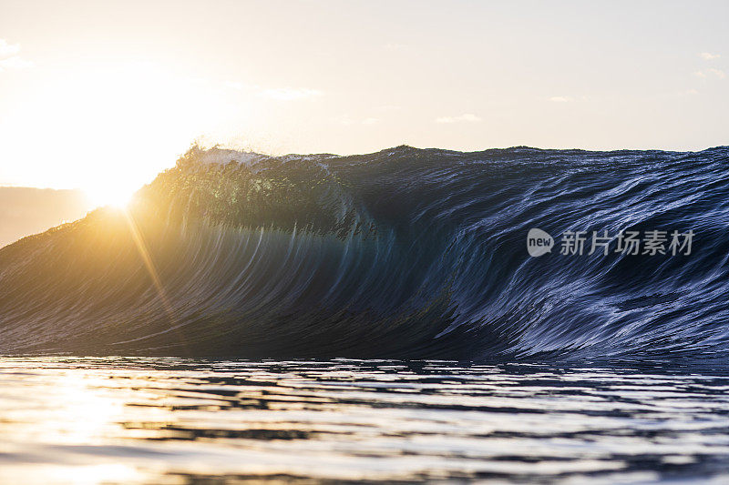 在温暖的早晨阳光照耀下，在海洋中形成平滑的波浪