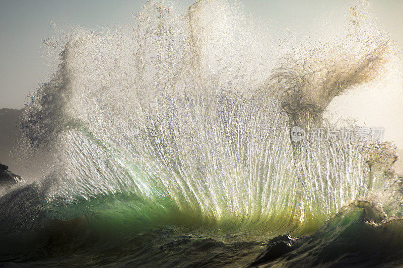 海洋能量碰撞和爆炸成金色的光形成一个水的纹理扇