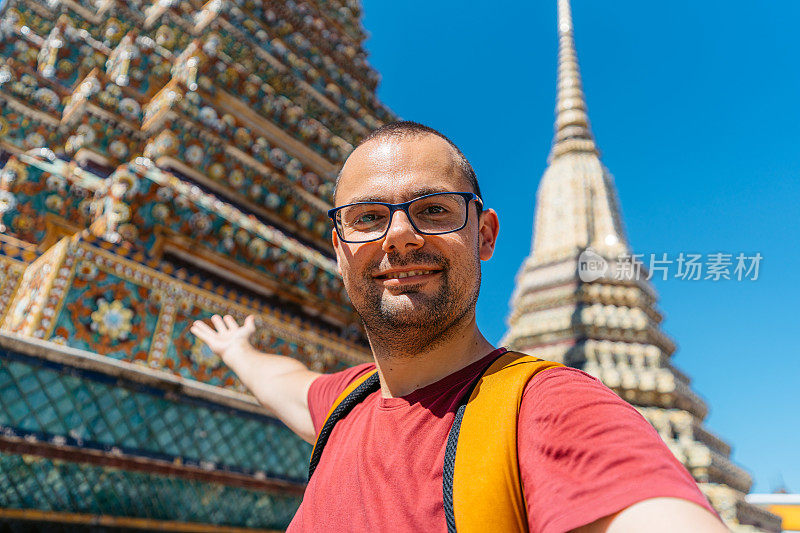 在泰国曼谷卧佛寺自拍的年轻人