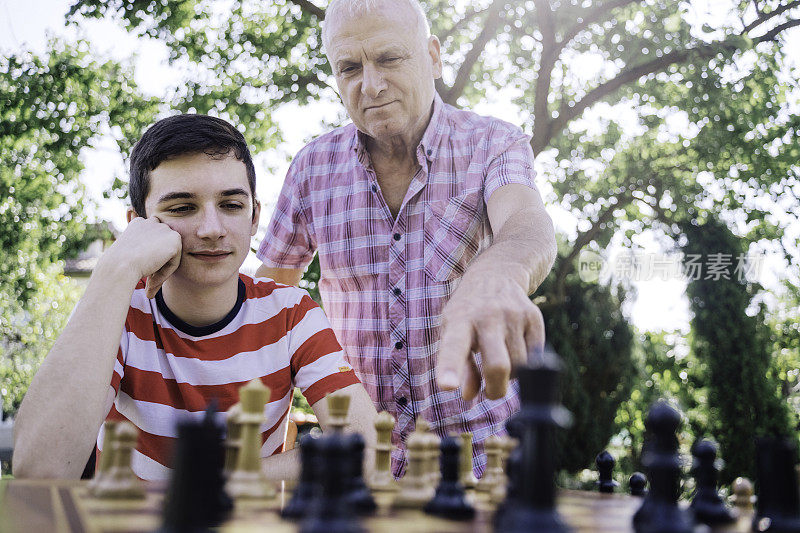 爷爷和孙子在一起下棋。