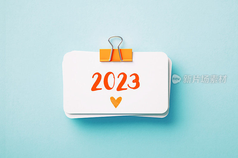 2023年，用蓝色背景的橙色回形针夹住的打印便条