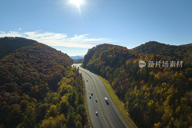 从北卡罗莱纳州的I-40高速公路上俯瞰，通往阿什维尔，穿过阿巴拉契亚山脉，黄色的秋天树林和快速移动的卡车和汽车。州际运输概念