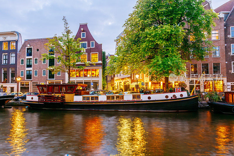 黄昏时分的阿姆斯特丹运河:传统的荷兰建筑和船只。