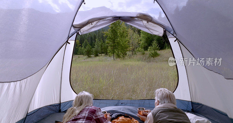 成熟的夫妇在山上的草地上露营