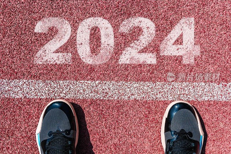 2024年的开始写在多彩的道路上。即将到来的2024年新年的概念照片。新年理念，动力，事业提升，迈步前进，前进，希望