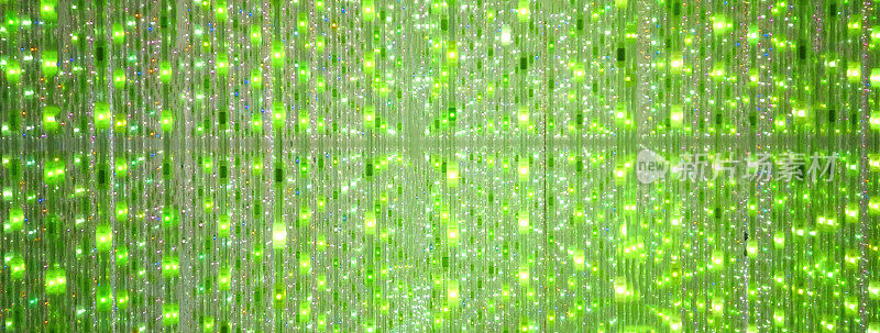 绿色舞台背景的LED闪烁和闪烁灯泡。明亮的背景。