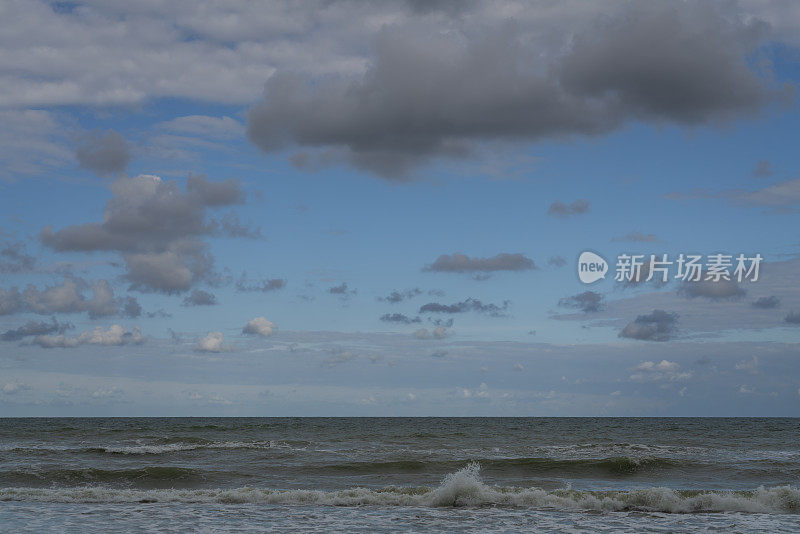 在一个晴朗的夏日，俄罗斯加里宁格勒地区的库尔斯沙嘴，暴风雨中的波罗的海映衬着多云的天空