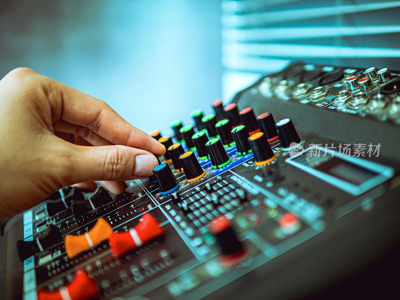 录音师在录音室、广播室、混音室调节混音器的手特写。专业的音频混音控制台，按钮，滑动器和滑块。声音检查。