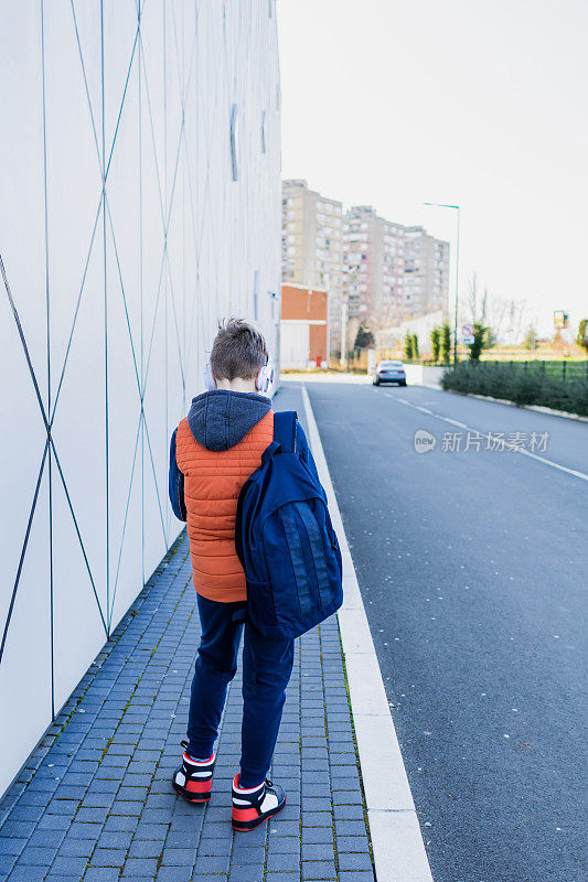 一个戴耳机的男生放学后要回家。