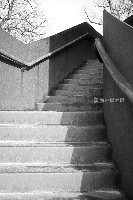 户外楼梯的黑白形象，金属栏杆，传达上升感和神秘感。
