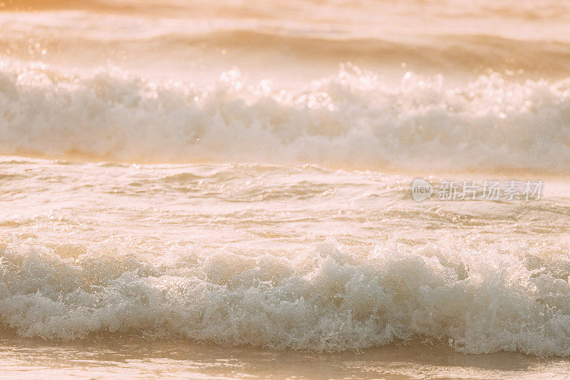 海面海面上有泡沫的小波浪。令人惊叹的风景。海水泡沫溅起，冲刷着沙滩。沙滩海岸线上的海浪。美丽的背景。自然背景。近距离