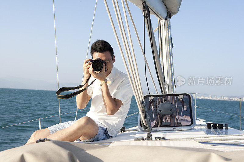 青年男子在帆船上拍照