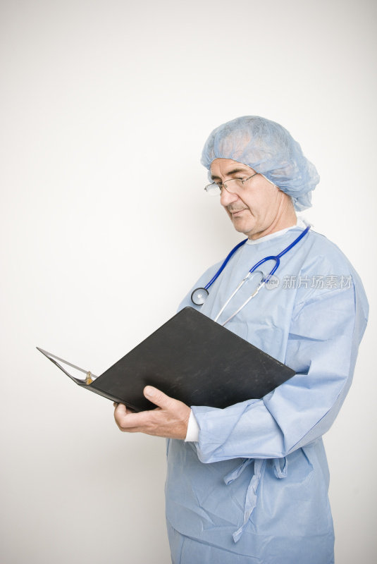 穿着手术服的医生在看病历。